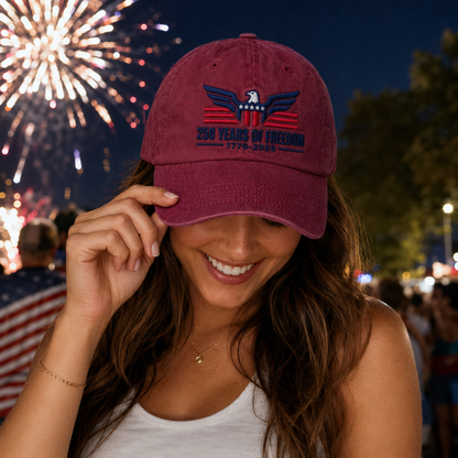 Woman at a night celebration with fireworks wearing a maroon washed baseball cap with white embroidered text design