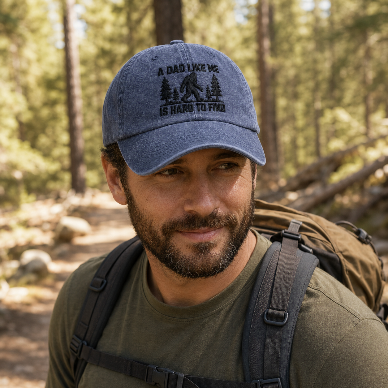 Man backpacking through a forest wearing a navy washed baseball cap with black embroidered bigfoot quote text
