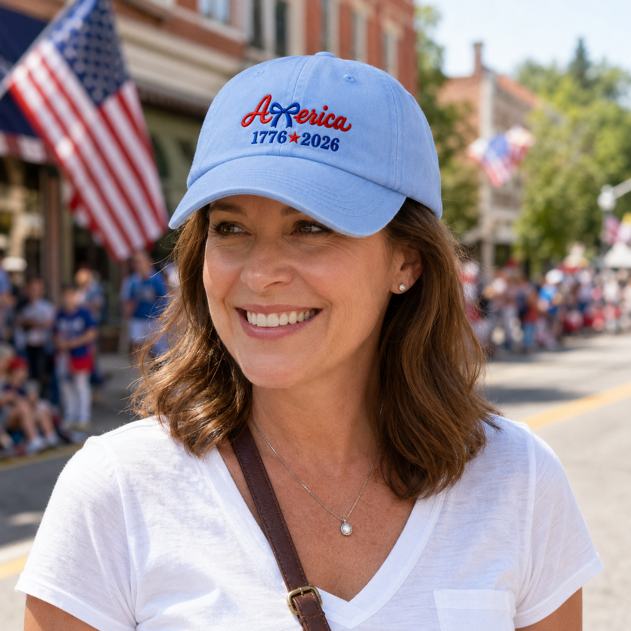 Woman smiling at a 4th of July parade wearing a light blue washed baseball cap with patriotic embroidery