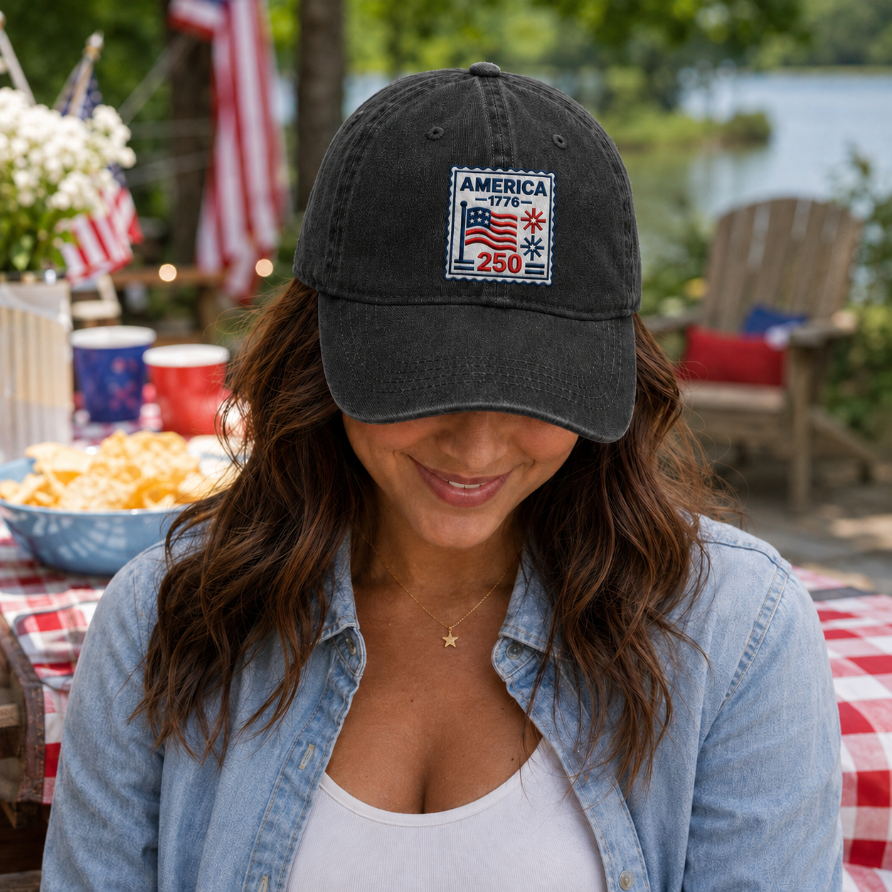 Woman smiling at a 4th of July backyard picnic wearing a black washed baseball cap with embroidered America 250 stamp