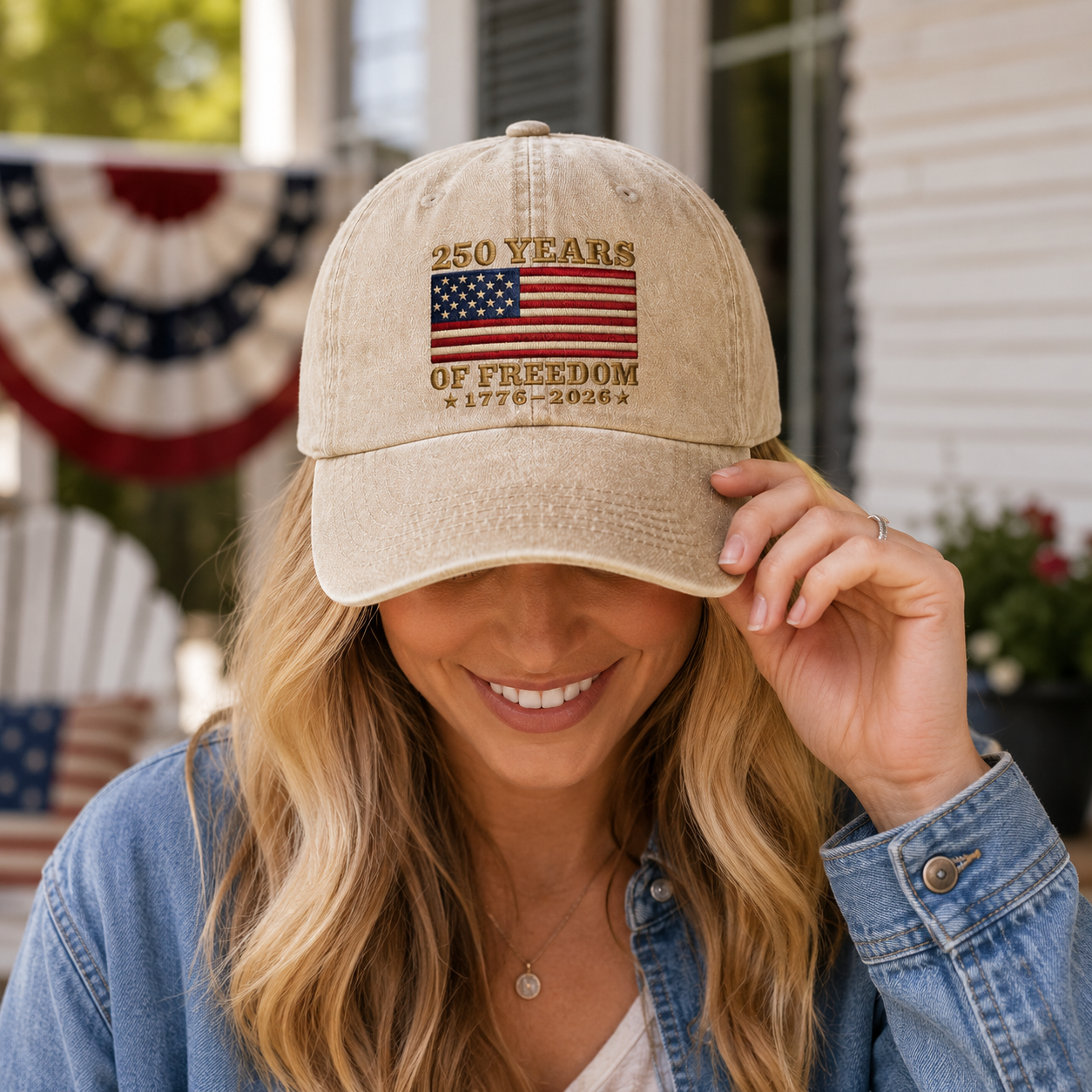 Woman adjusting a sand washed cotton baseball cap with embroidered US flag design on a patio near patriotic bunting