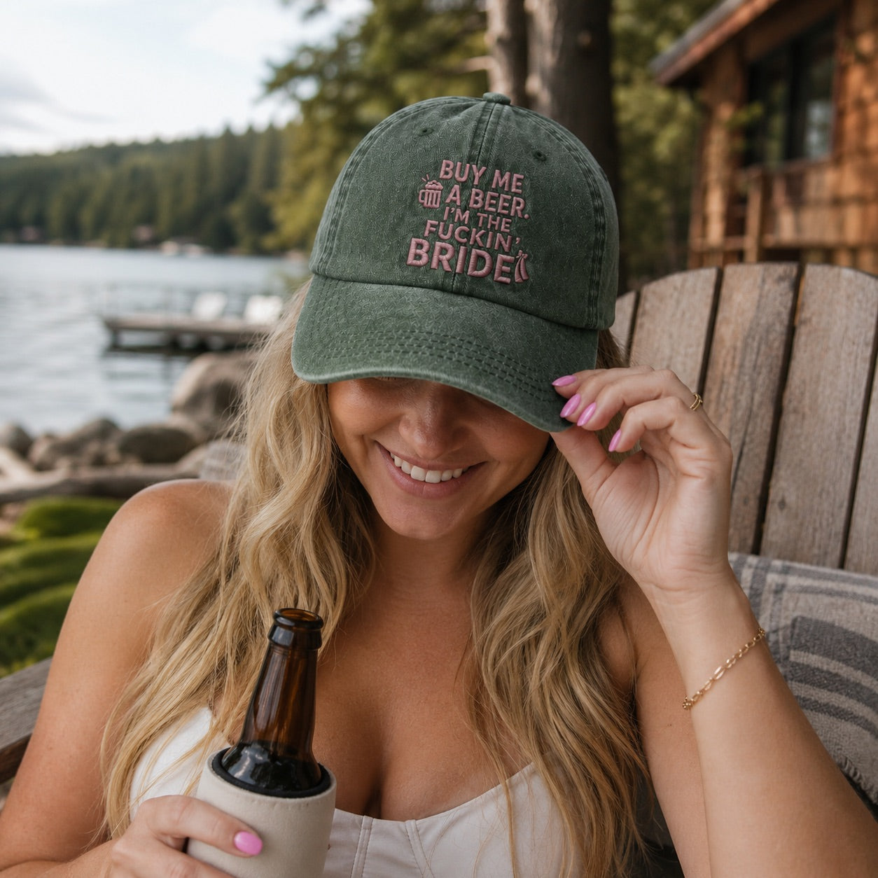 Woman wearing a cap with text by a lake and cabin