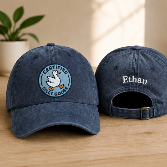 Two blue baseball caps with a logo and text on a wooden surface.
