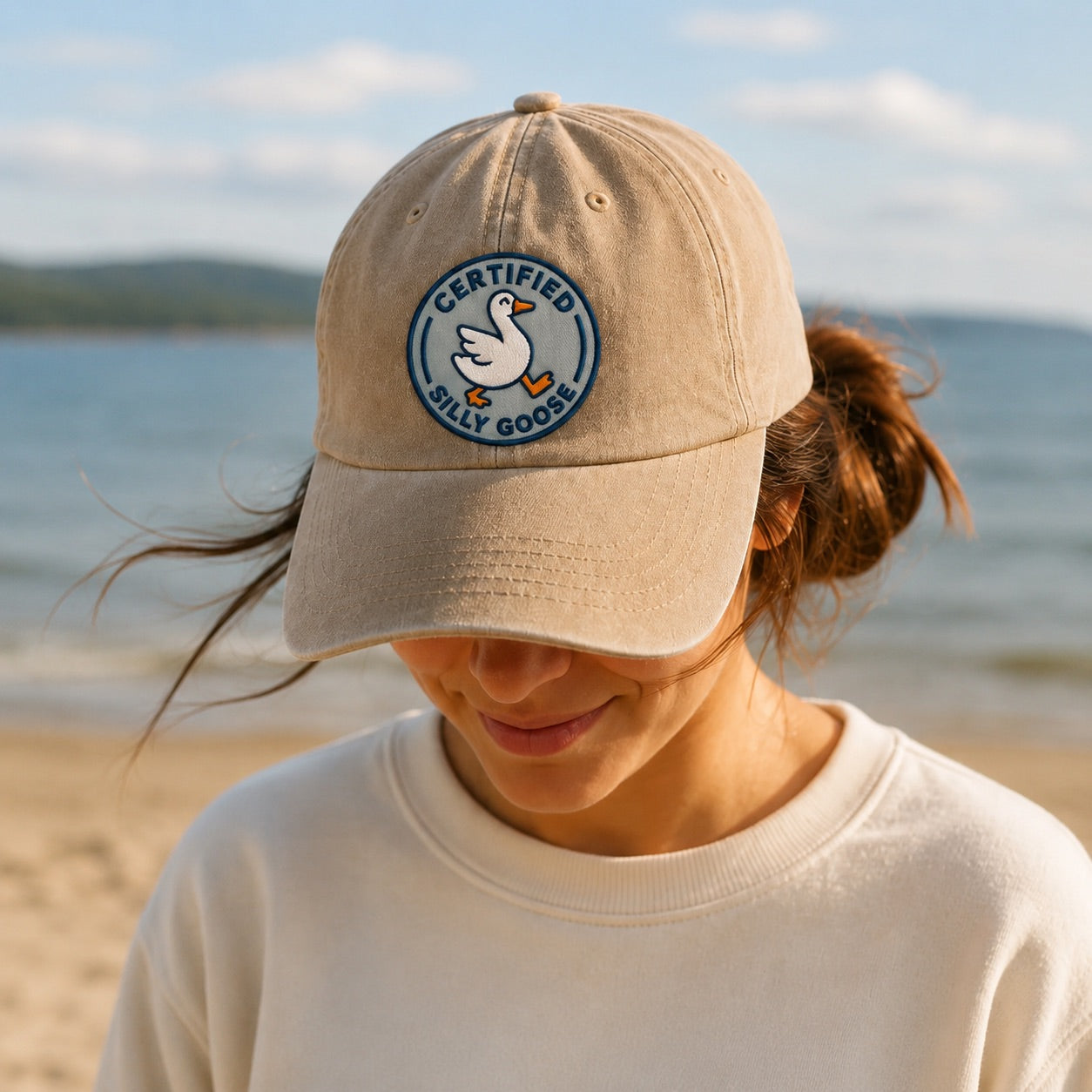 Person wearing a beige cap with a logo on a beach