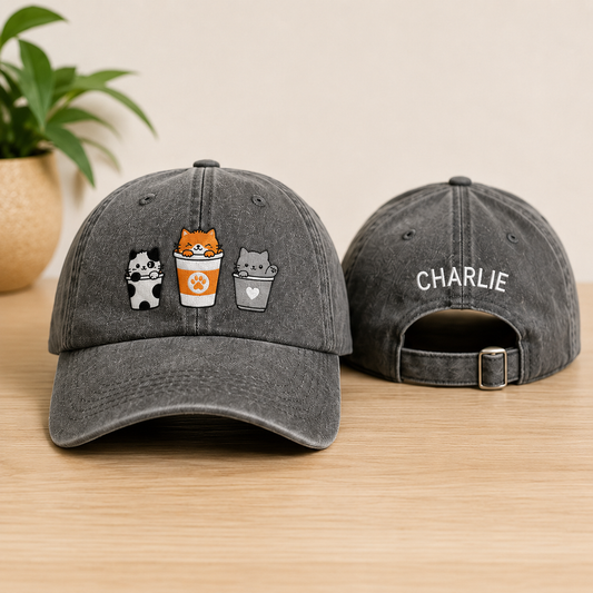 Gray baseball cap with embroidered designs on a wooden surface