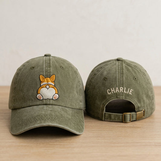 Green baseball cap with a dog illustration on the front and 'CHARLIE' on the back, placed on a wooden surface.