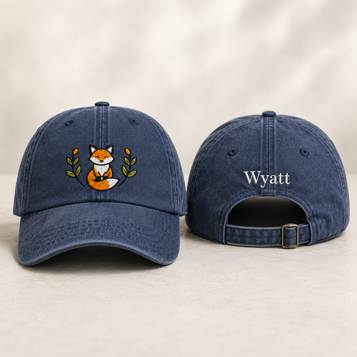 Front and back view of a navy washed baseball cap with embroidered fox design and custom name Wyatt text