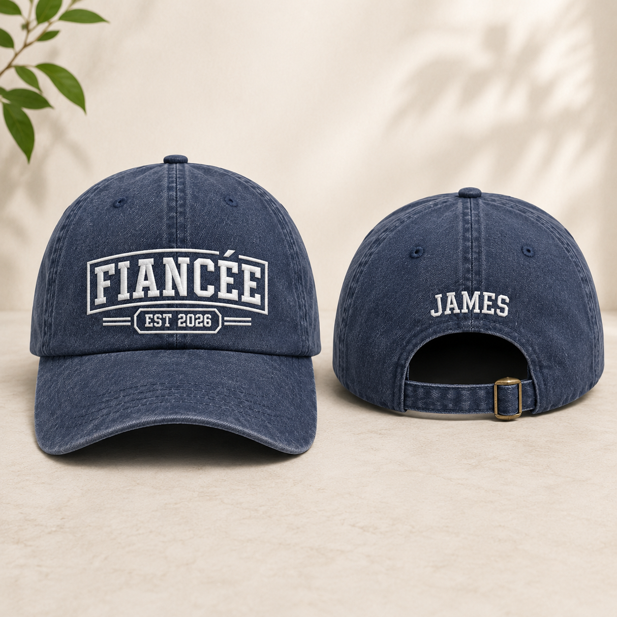 Front and back view of a navy washed baseball cap with white embroidered fiancee est 2026 text and personalized name