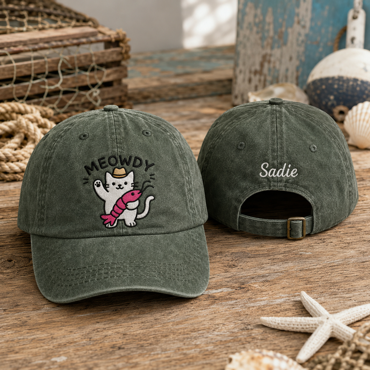 Front and back view of an army green washed cotton baseball cap featuring an embroidered cartoon cat holding a crawfish and custom name Sadie text