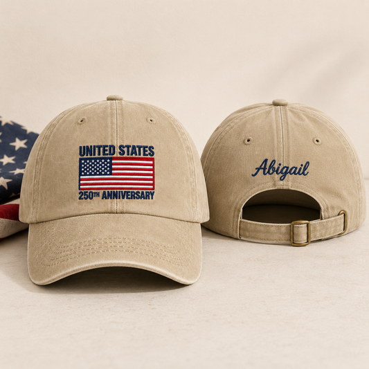 Front and back view of a sand washed baseball cap with embroidered US flag United States 250th anniversary design and custom blue name Abigail