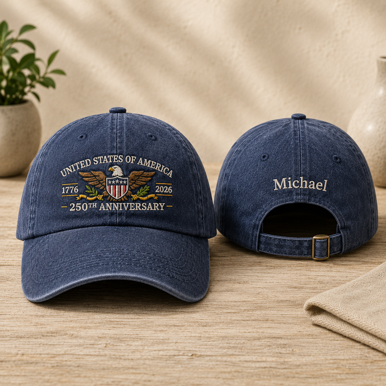 Front and back view of a navy washed baseball cap with gold embroidered United States of America 250th anniversary eagle design and custom name text
