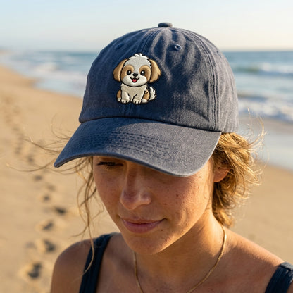 Person wearing a blue cap with a dog illustration on a beach