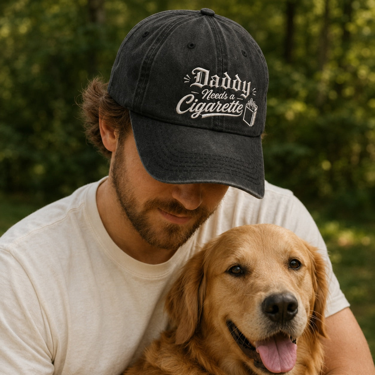 Man wearing a cap with 'Daddy Needs a Cigarette' text, sitting with a dog outdoors.