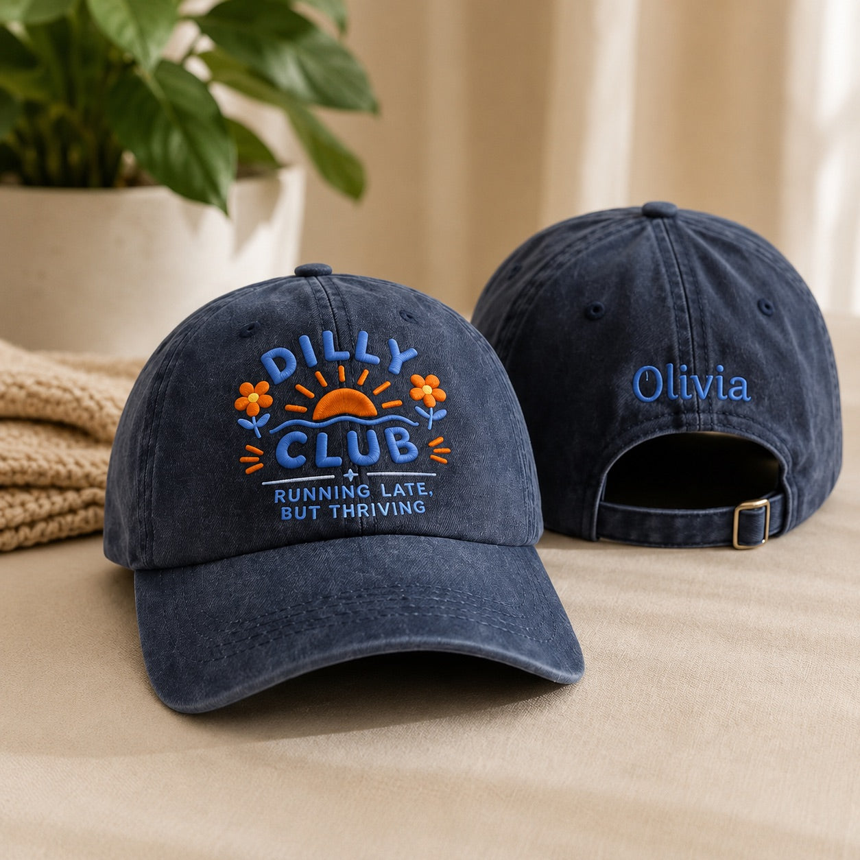Two navy blue baseball caps with embroidered designs on a beige surface.