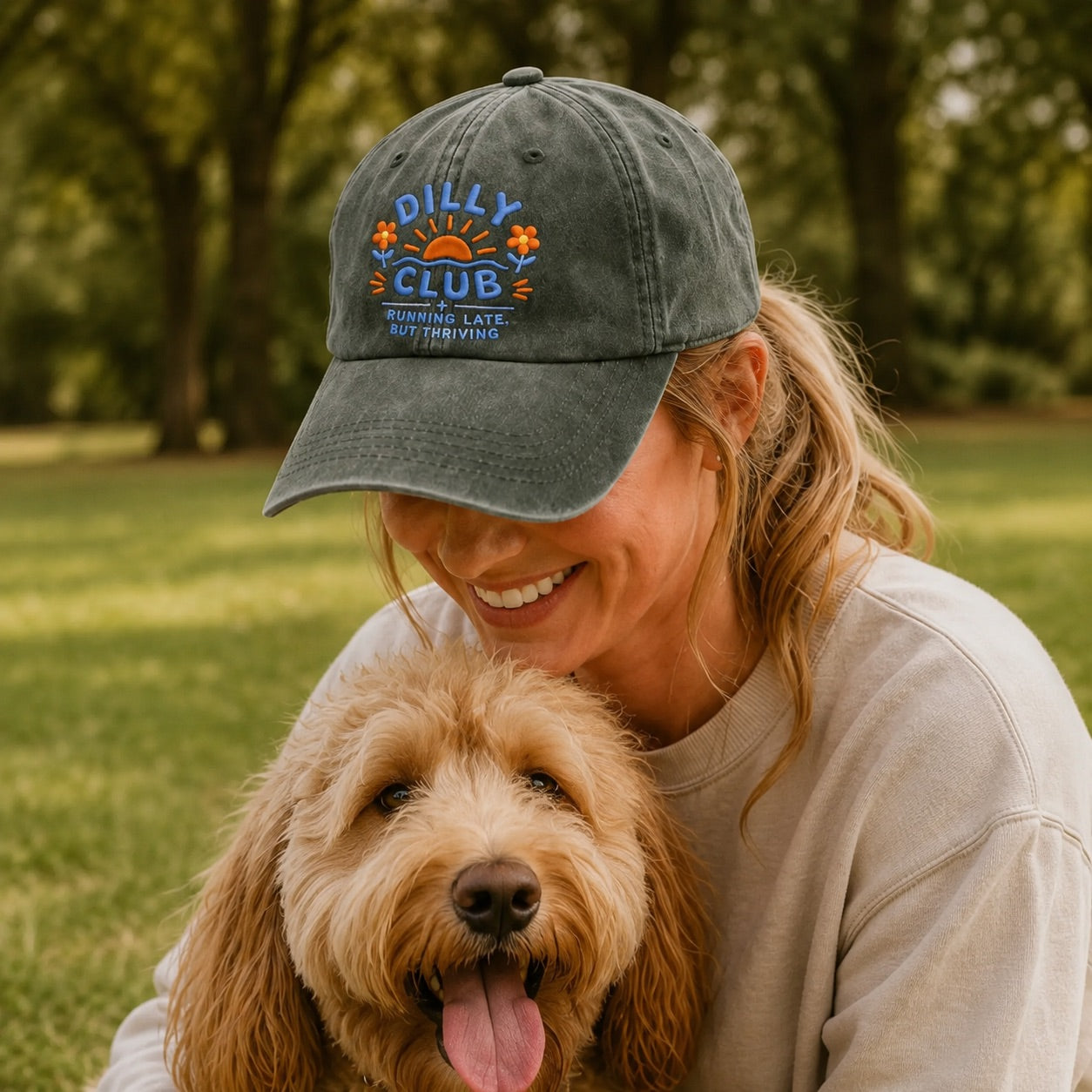 Woman wearing a cap with 'Dilly Club' logo and a dog in a park