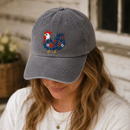 Person wearing a gray cap with a rooster design outdoors