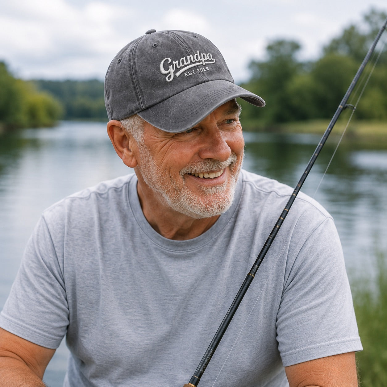 Man wearing a cap labeled 'Grandpa' by a lake, holding a fishing rod.