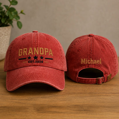 Two red baseball caps with embroidered text on a wooden surface.