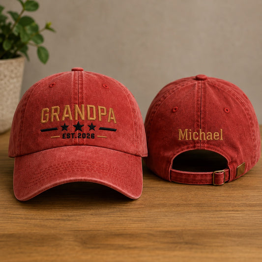 Two red baseball caps with embroidered text on a wooden surface.