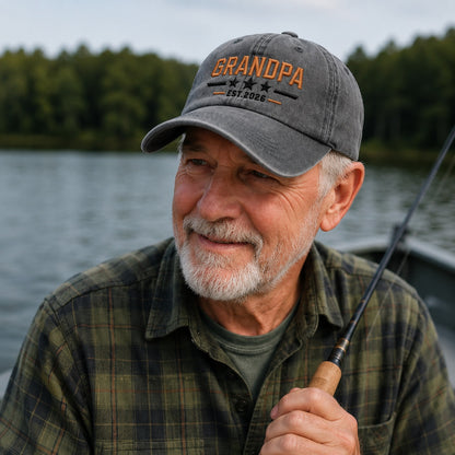 Man wearing a 'GRANDPA' cap by a lake