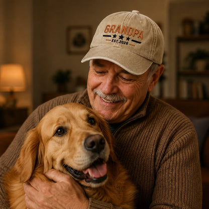 Man wearing a 'GRANDPA' cap with a dog in a cozy living room.