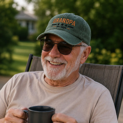 Man wearing a 'Grandpa' cap holding a mug outdoors