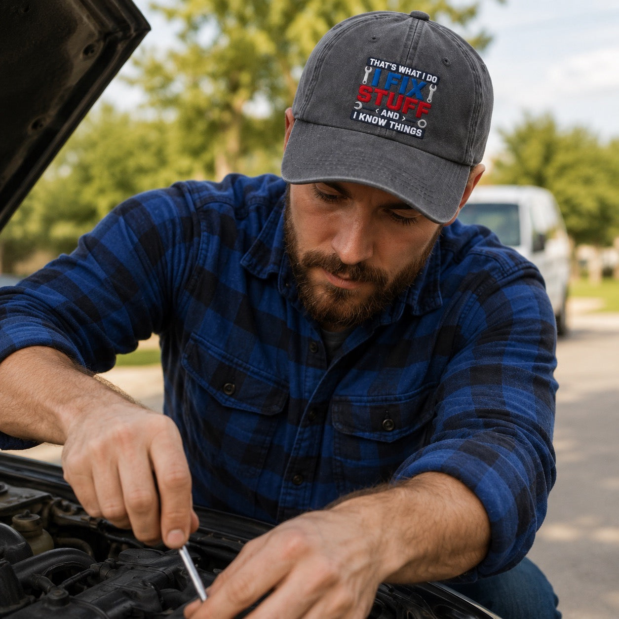 Man working on a car engine wearing a cap with text.