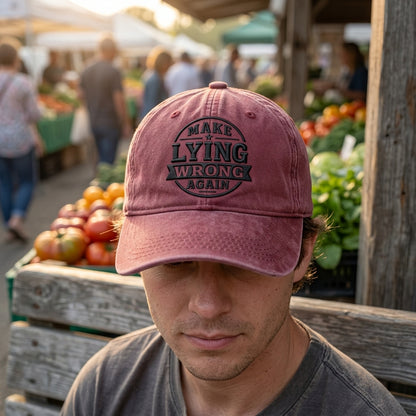 Man wearing a pink cap with text at an outdoor market.
