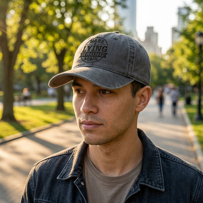 Man wearing a cap with text in a park setting