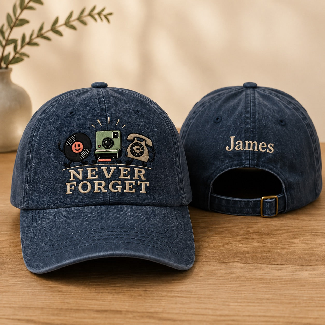 Blue denim cap with 'Never Forget' design and 'James' embroidery on a wooden surface.
