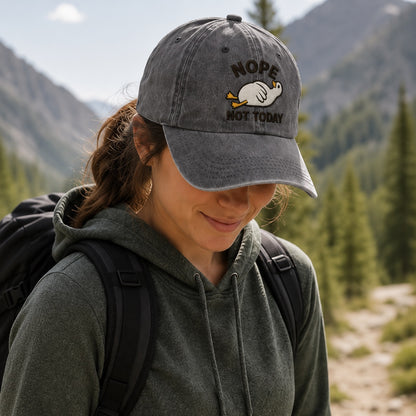 Person wearing a cap with 'Nope Not Today' text in a mountainous forest setting