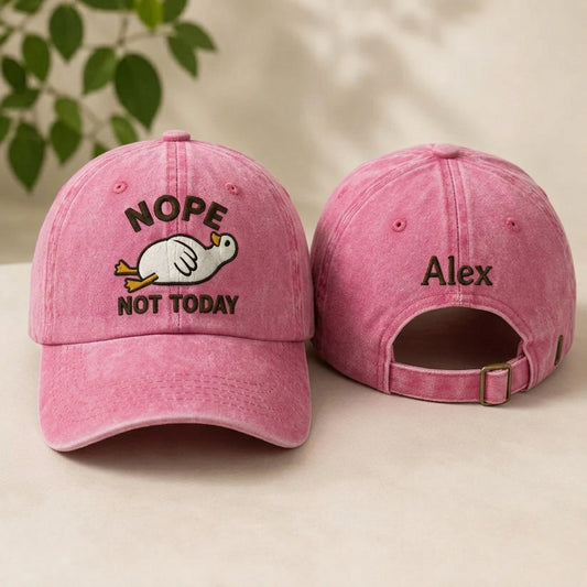 Two denim baseball caps with embroidered designs on a neutral background
