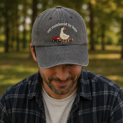 Man wearing a cap with a duck graphic and text in a park setting
