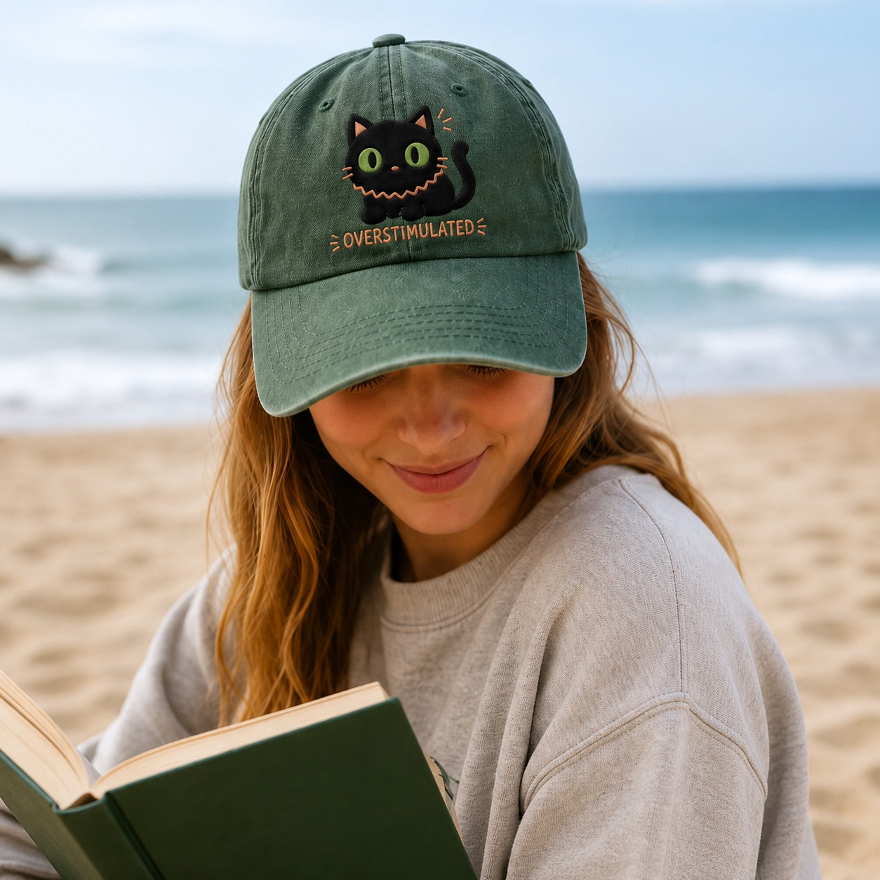Person wearing a cap with a cat design on a beach