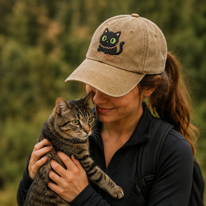 Woman holding a cat wearing a cap with a cat design outdoors