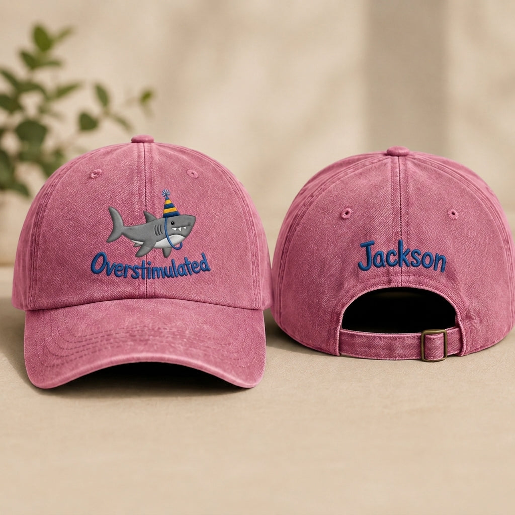 Two gray baseball caps with embroidered designs on a beige background