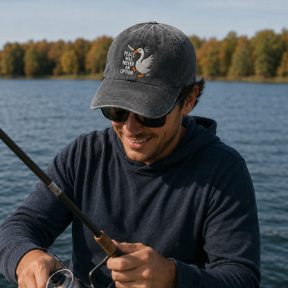 Man fishing by a lake wearing a cap with a duck design and sunglasses.