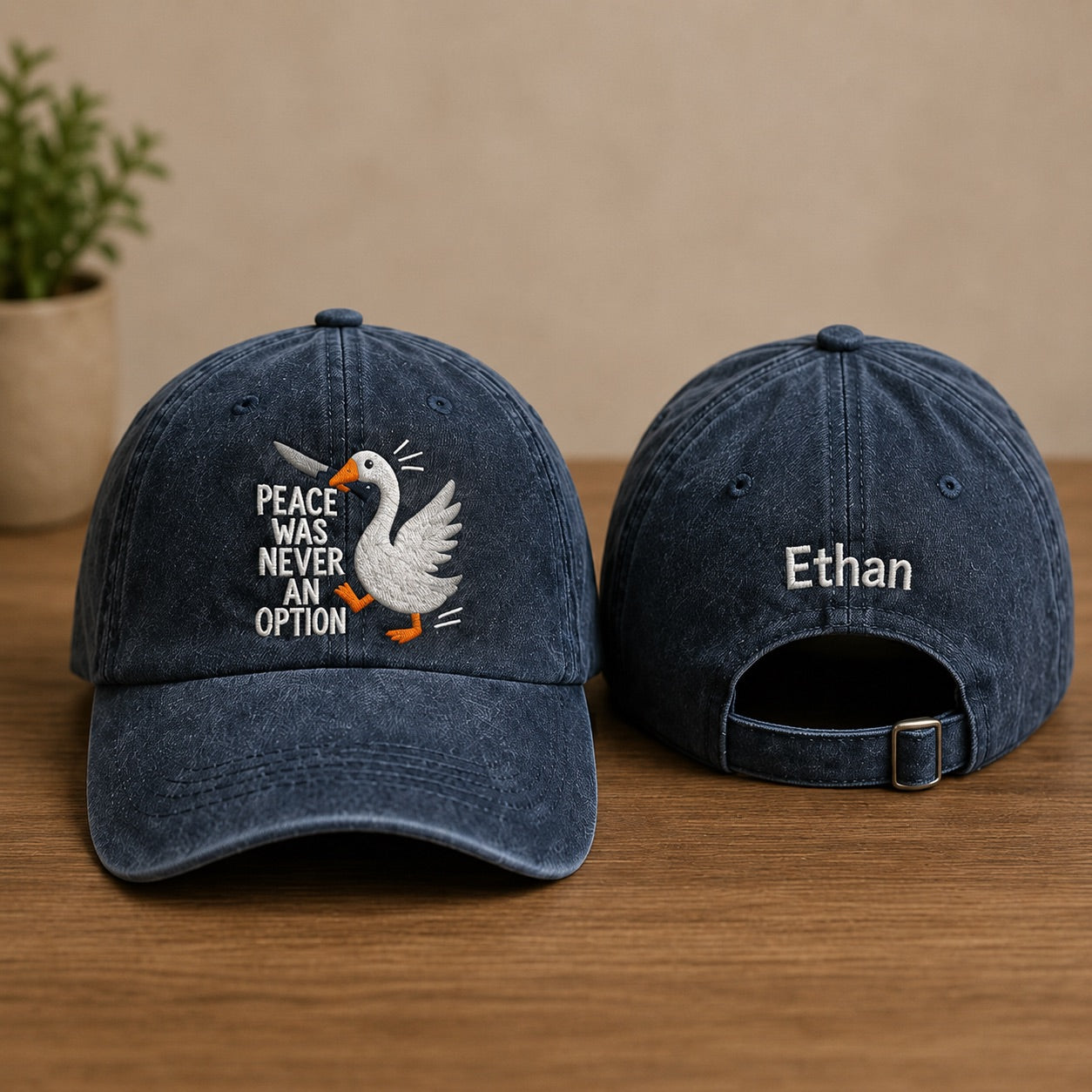Two blue denim caps with a goose graphic and text on a wooden surface.