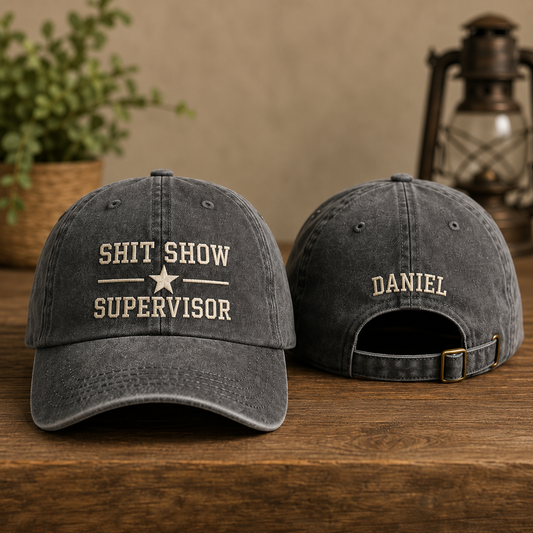 Two gray baseball caps with text on a wooden surface.