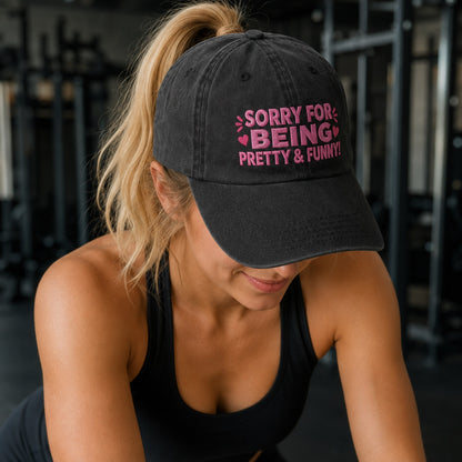 Woman wearing a black cap with pink text in a gym setting