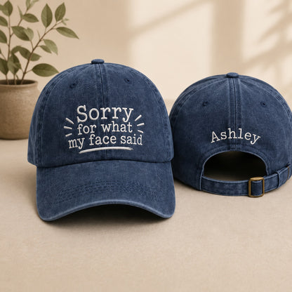Two blue baseball caps with text on a beige surface