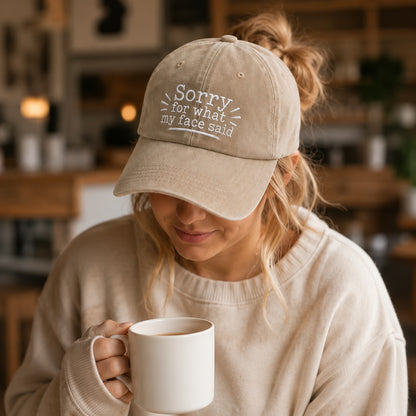 Person wearing a cap with text and holding a mug in a casual setting