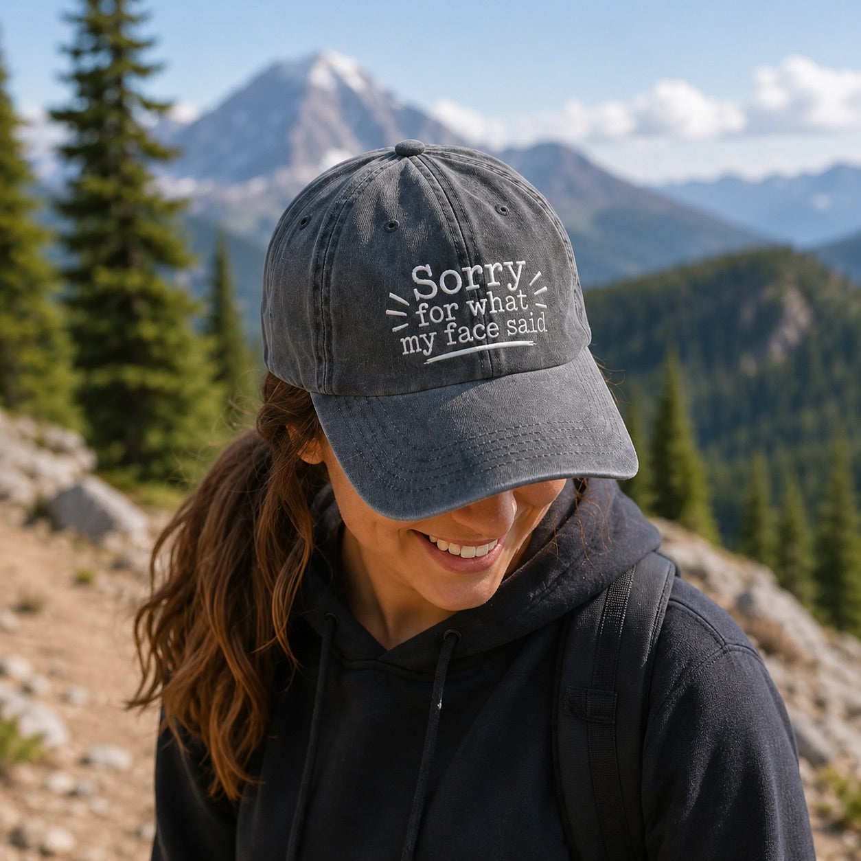 Person wearing a cap with text in a mountainous landscape