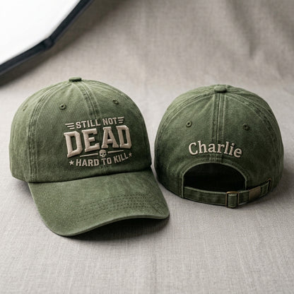 Two green baseball caps with text on a gray surface