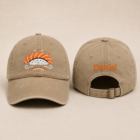 Beige cap with sushi design and 'Daniel' text on a beige background