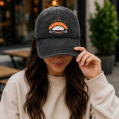 Person wearing a dark gray cap with a sushi design, outdoors.