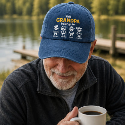 Man wearing a blue cap with 'This GRANDPA belongs to' text by a lake