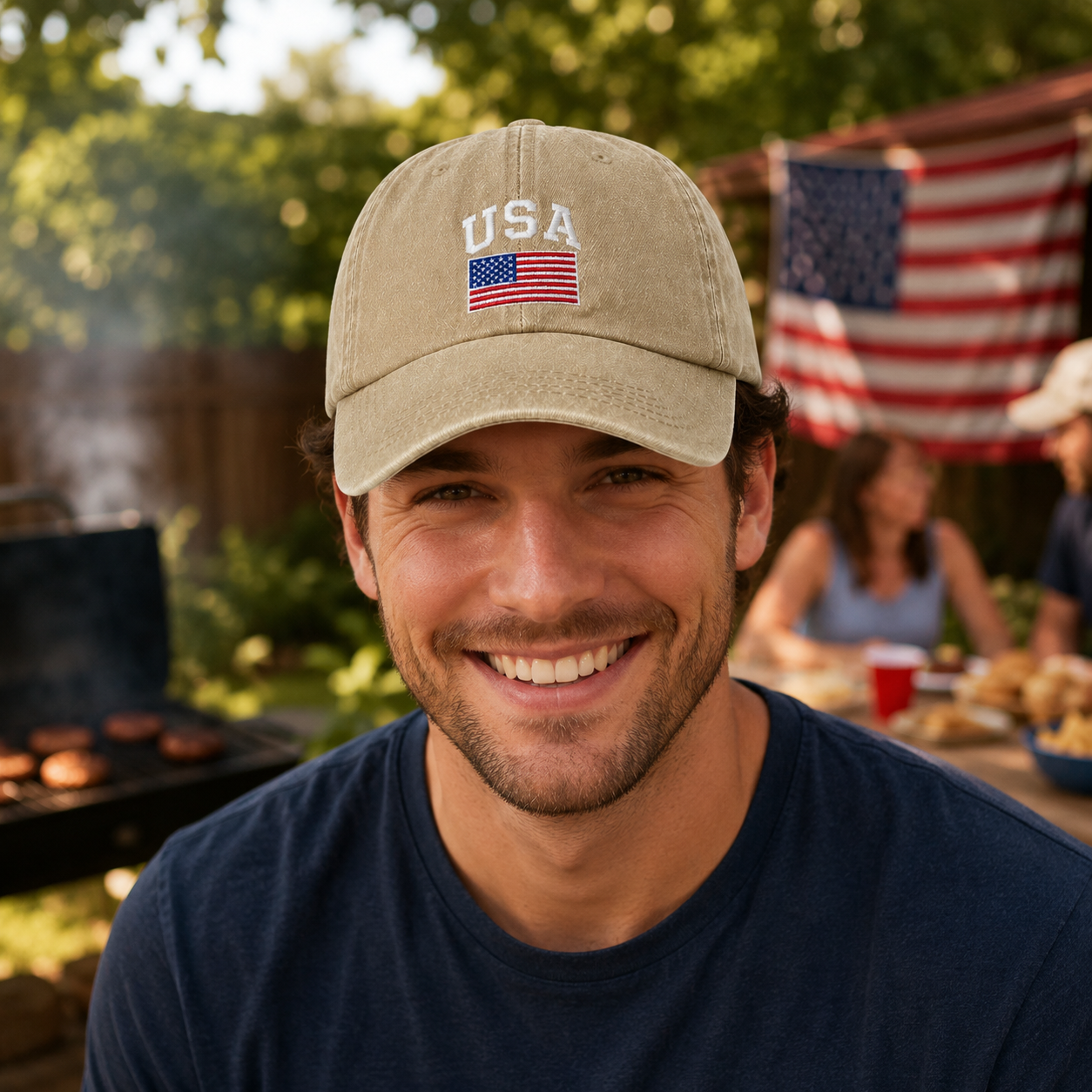 Man smiling at a backyard barbecue wearing a sand washed baseball cap with an embroidered USA flag design