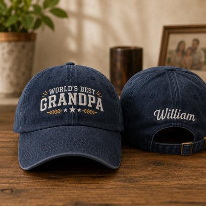 Two navy blue caps on a wooden surface with 'World's Best Grandpa' and 'William' text.