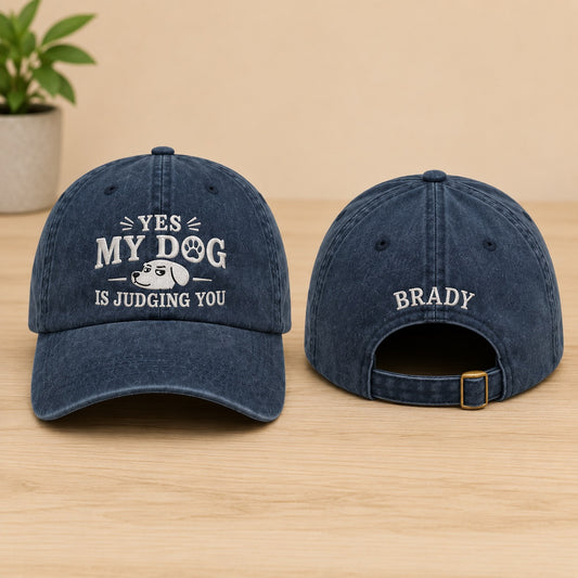 Two blue denim caps with text on a wooden surface